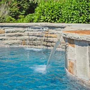 Stone retaining wall with custom-built waterfalls and landscaping
