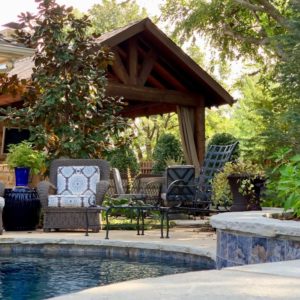 Backyard Pavilion with Seating area next to Pool